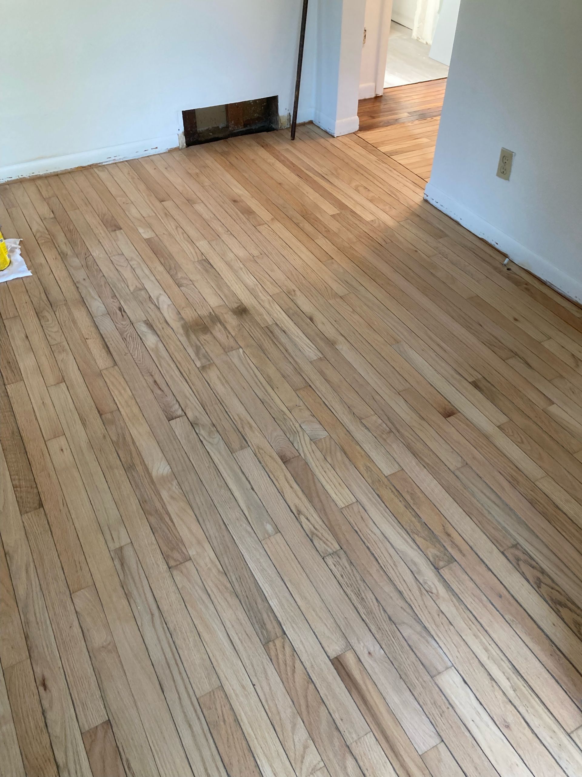 An empty room with hardwood floors and white walls.