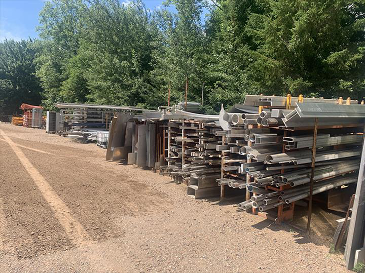 a bunch of metal pipes are stacked on top of each other in a yard .