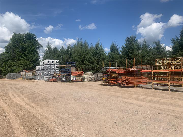 a lot of machinery is parked in a dirt lot .