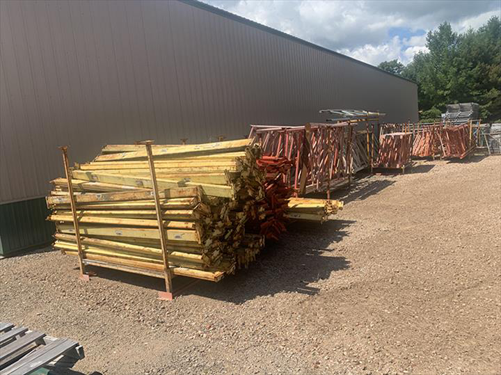 a pile of wooden scaffolding is sitting in front of a building .