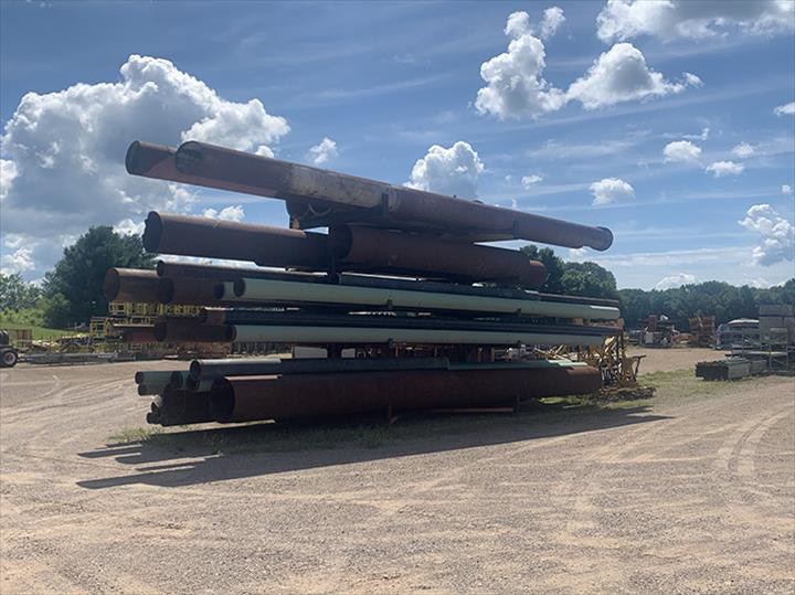 a pile of pipes stacked on top of each other in a dirt field .