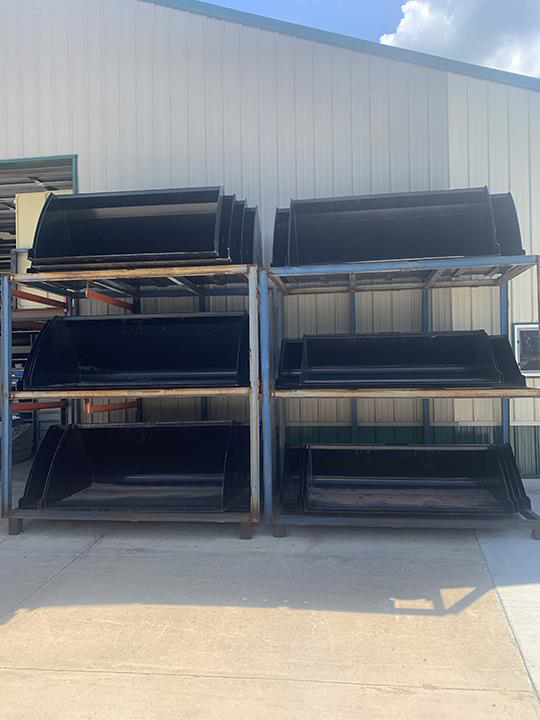 a bunch of black buckets are sitting on a shelf in front of a building .