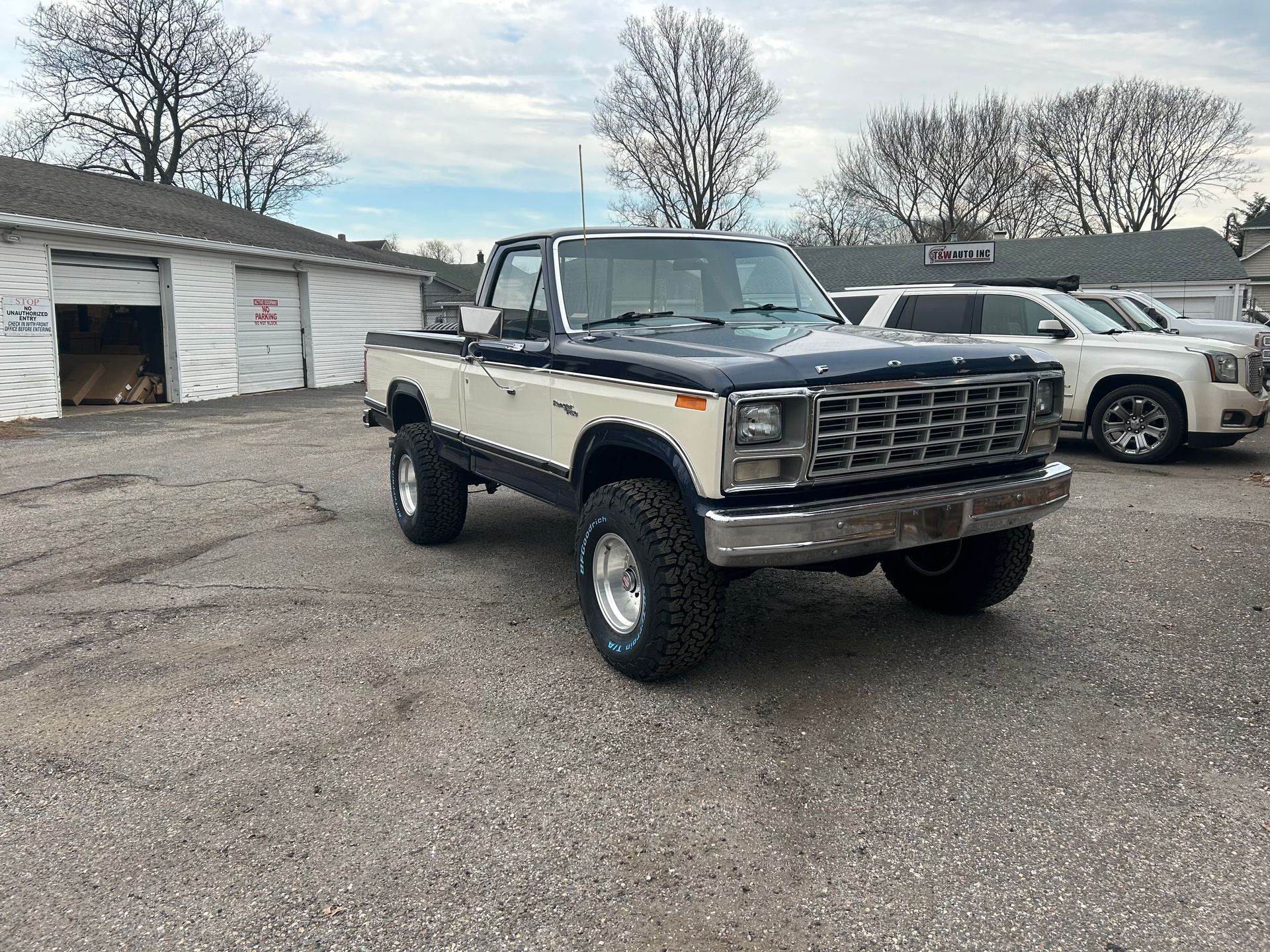 A white and black pickup truck is parked in a parking lot.