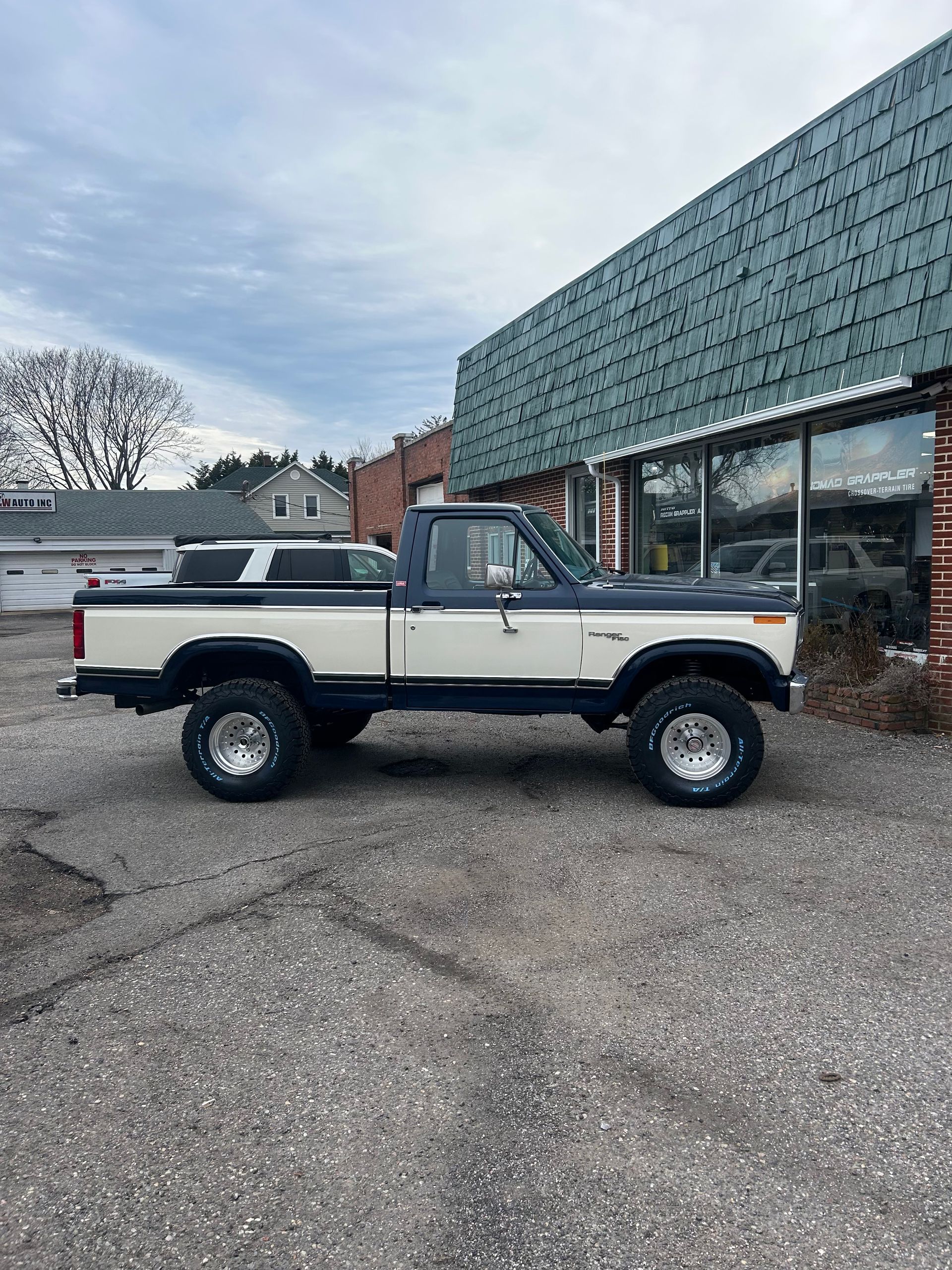 A white truck is parked in front of a building.