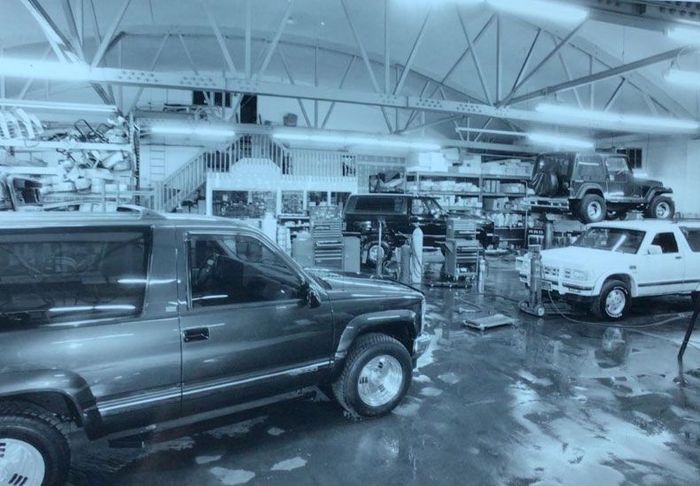 A black-and-white photo of cars in a garage.