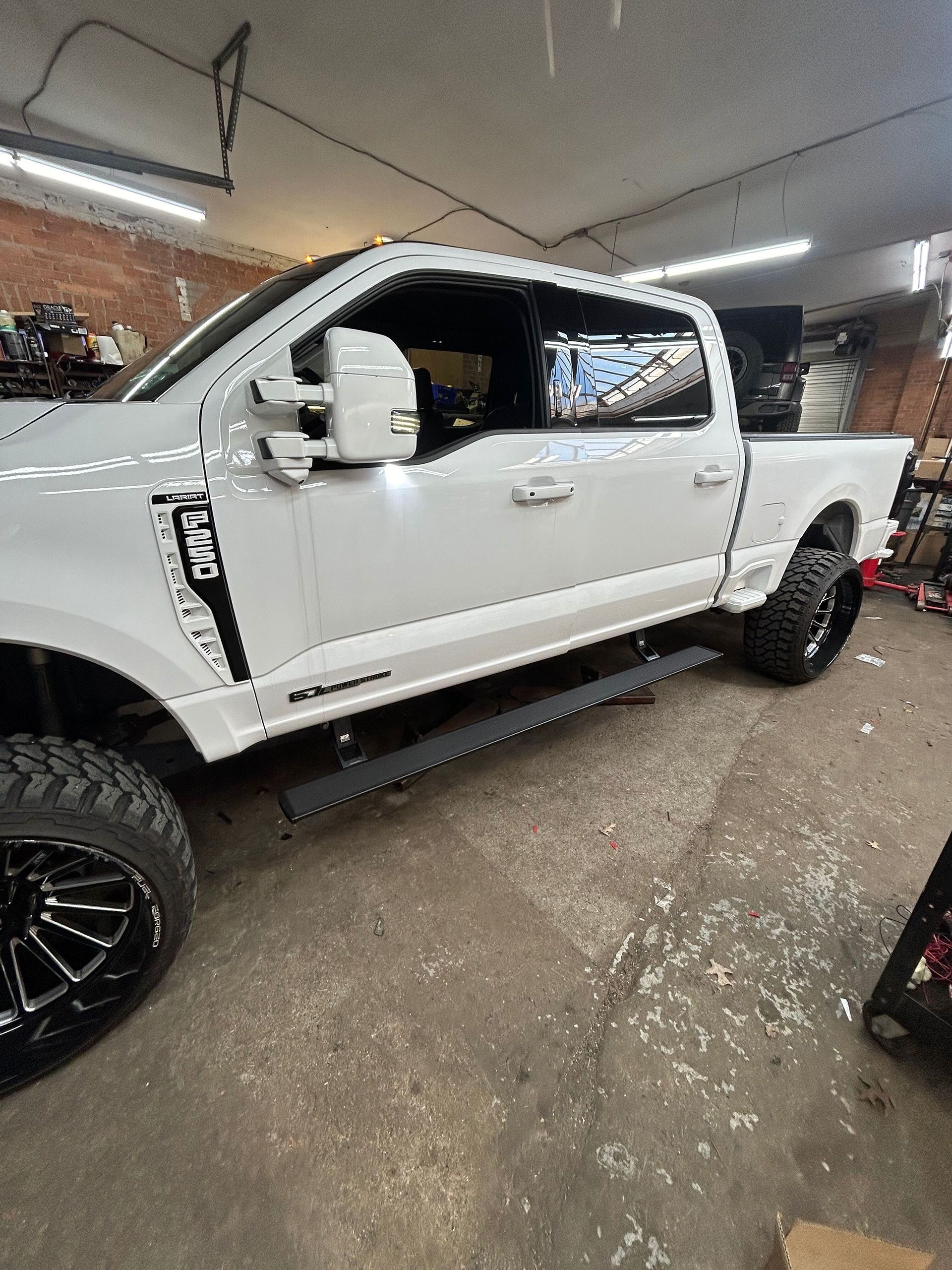 A white pickup truck is parked in a garage