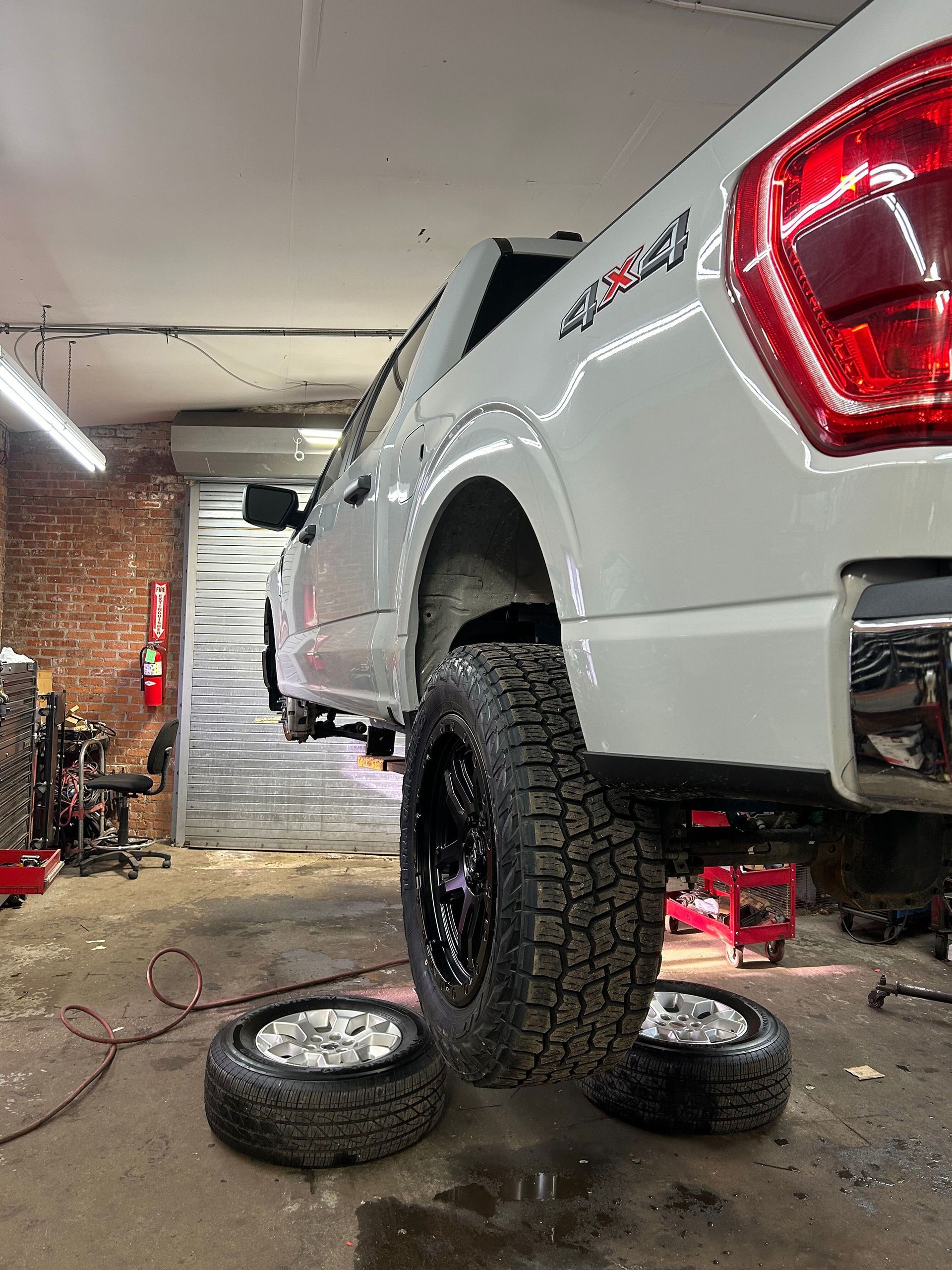 A white truck is being worked on in a garage