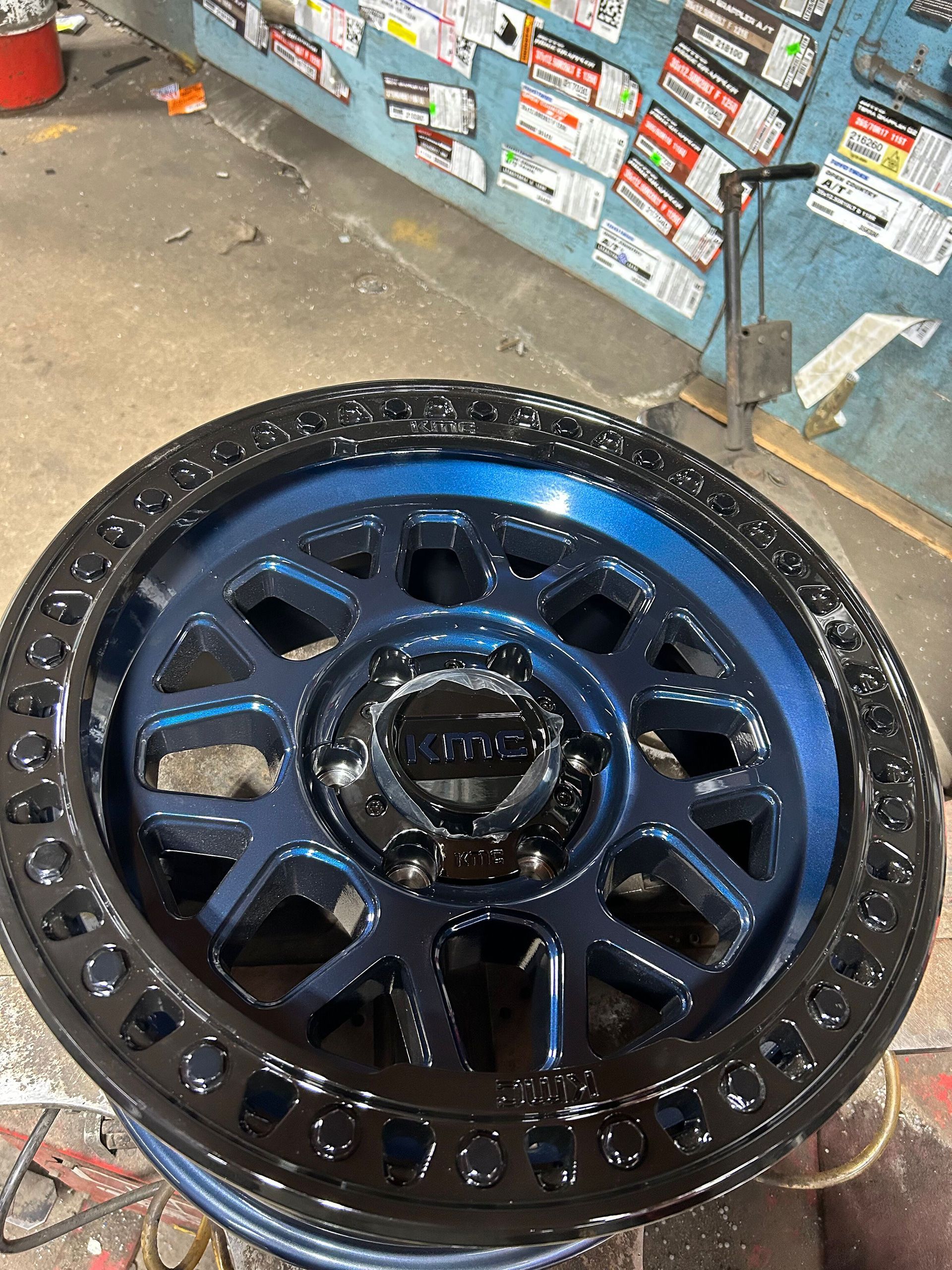A black and blue wheel on the ground in a garage