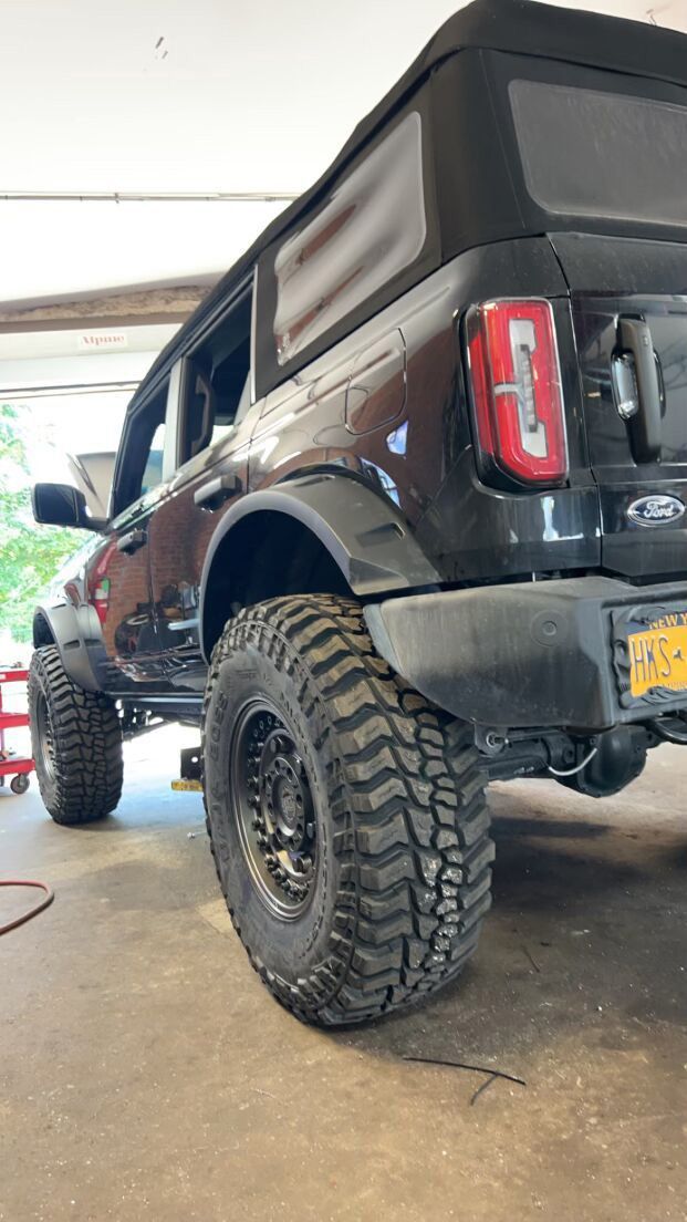 A black Ford Bronco is parked in a garage