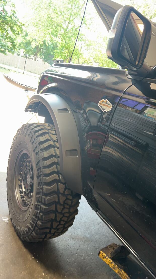 A black truck with a large tire
