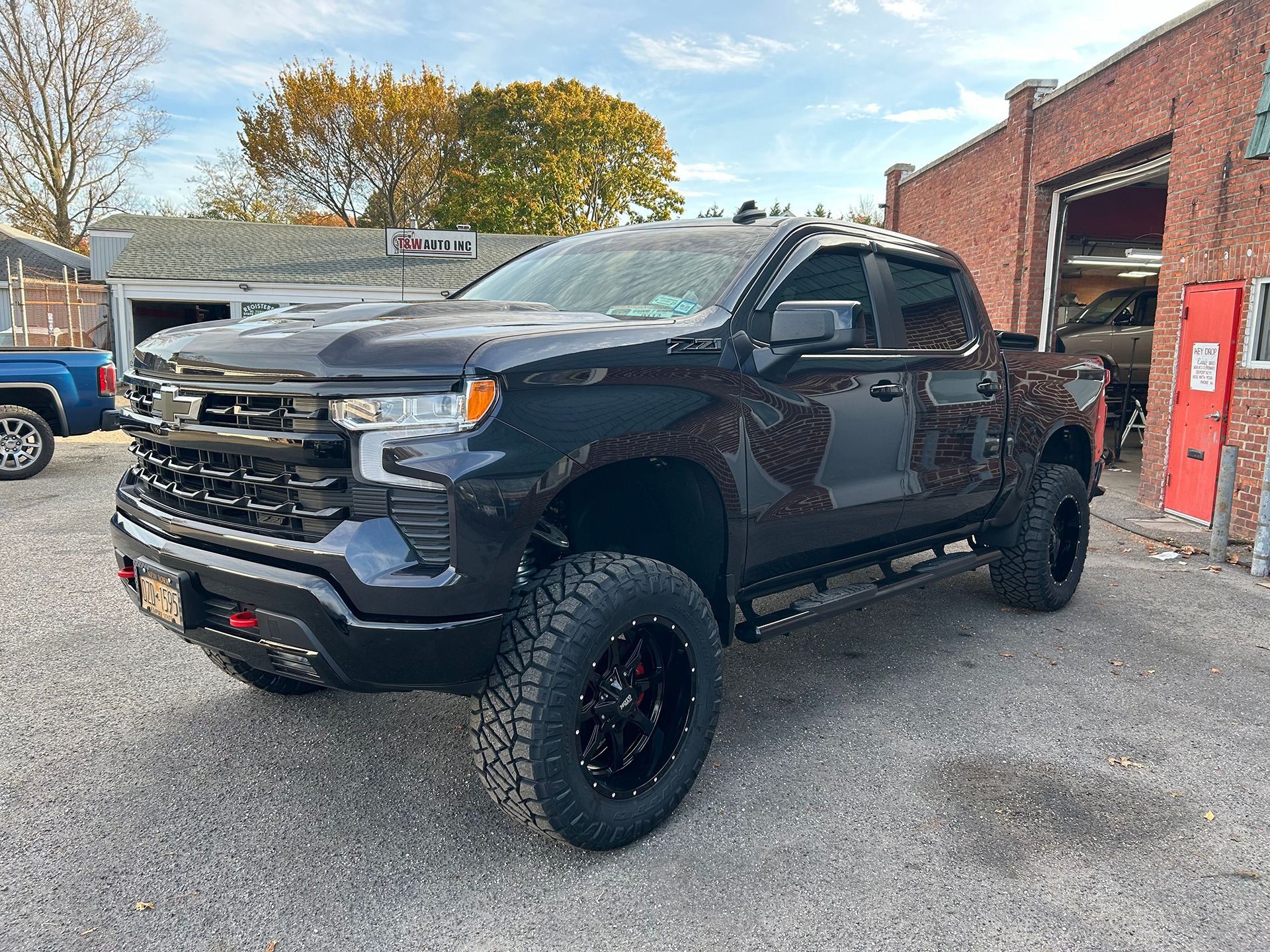 A black truck is parked in front of a brick building