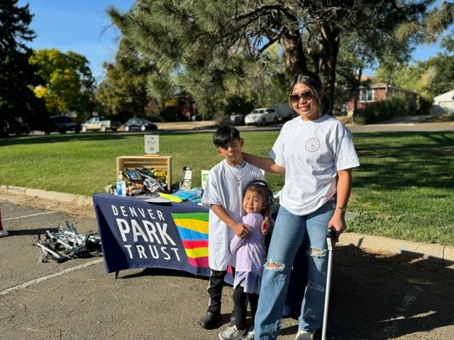 A woman and two children are standing in a park