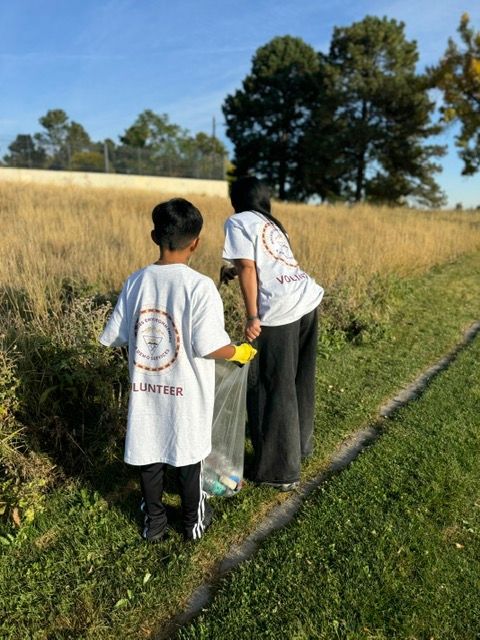 Two people are standing next to each other in a grassy field
