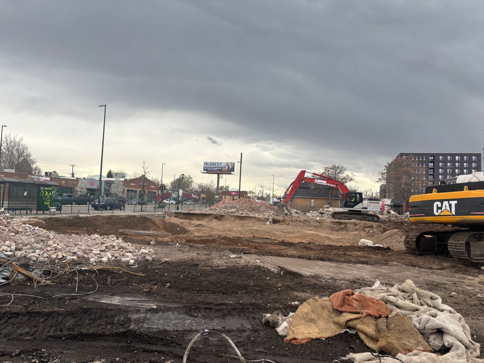 A construction site with a cat excavator in the middle of it.