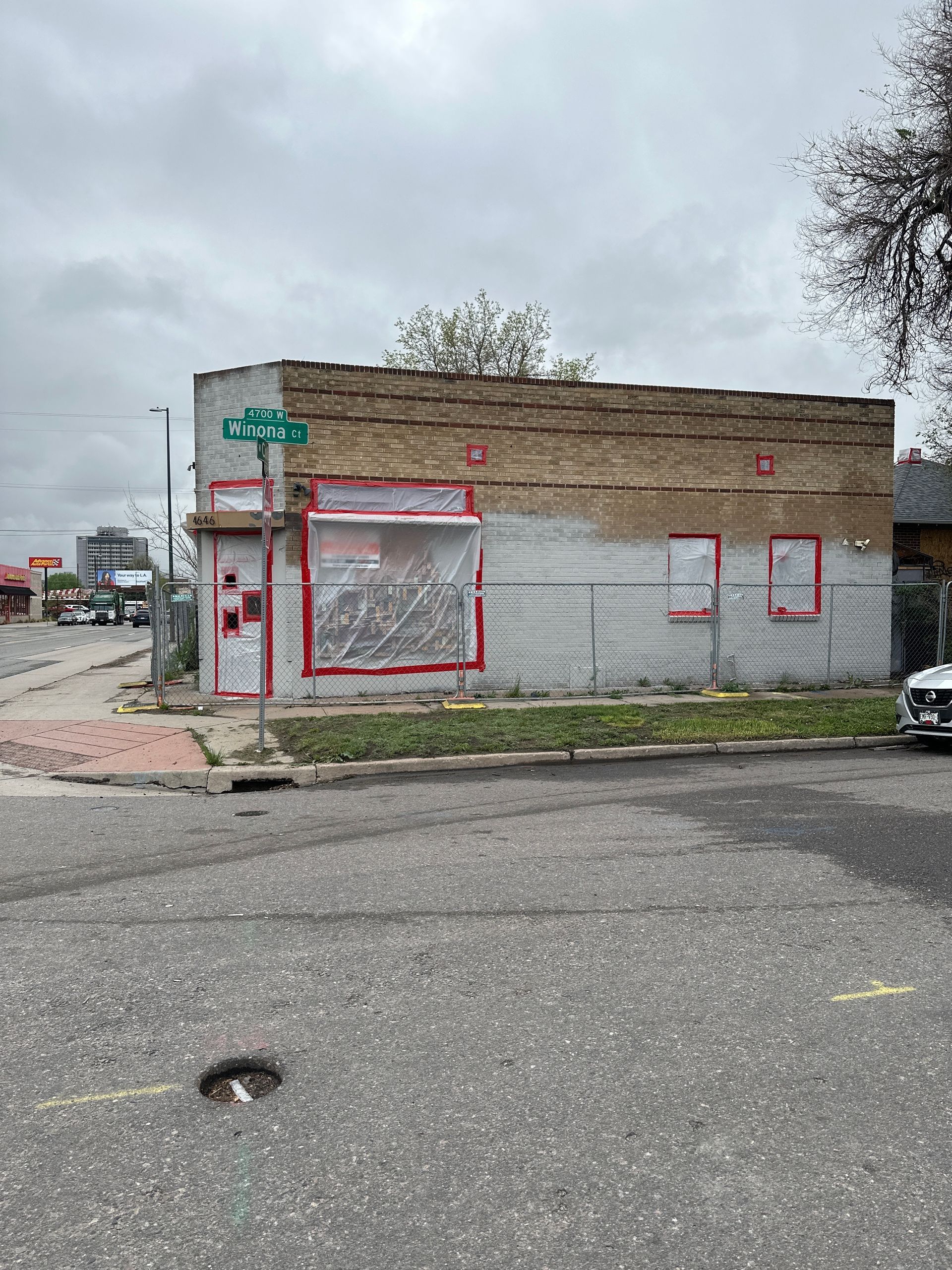 A man is standing on a ladder in a room with a hole in the ceiling.