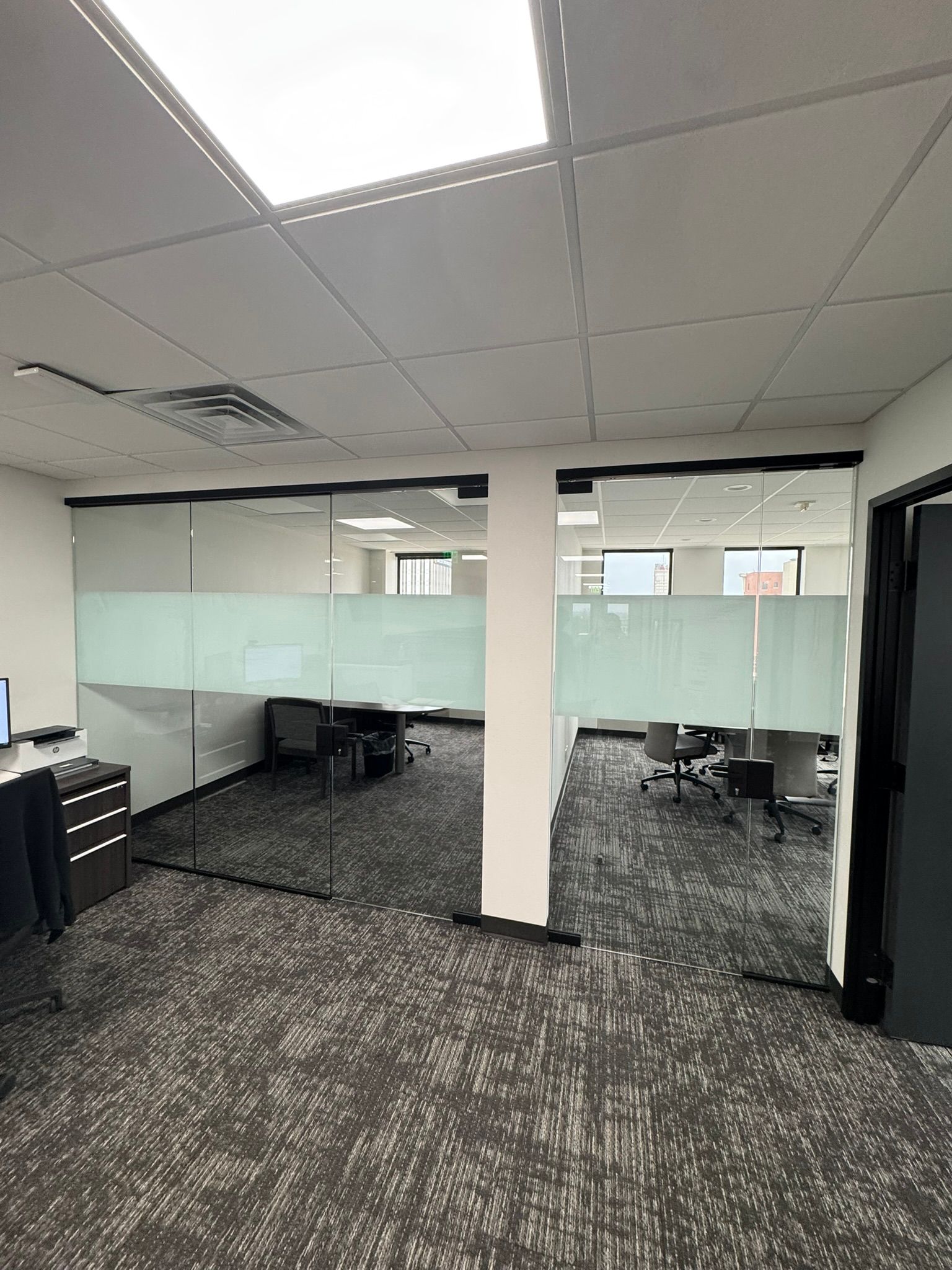 A large room with a carpeted floor and a glass wall.