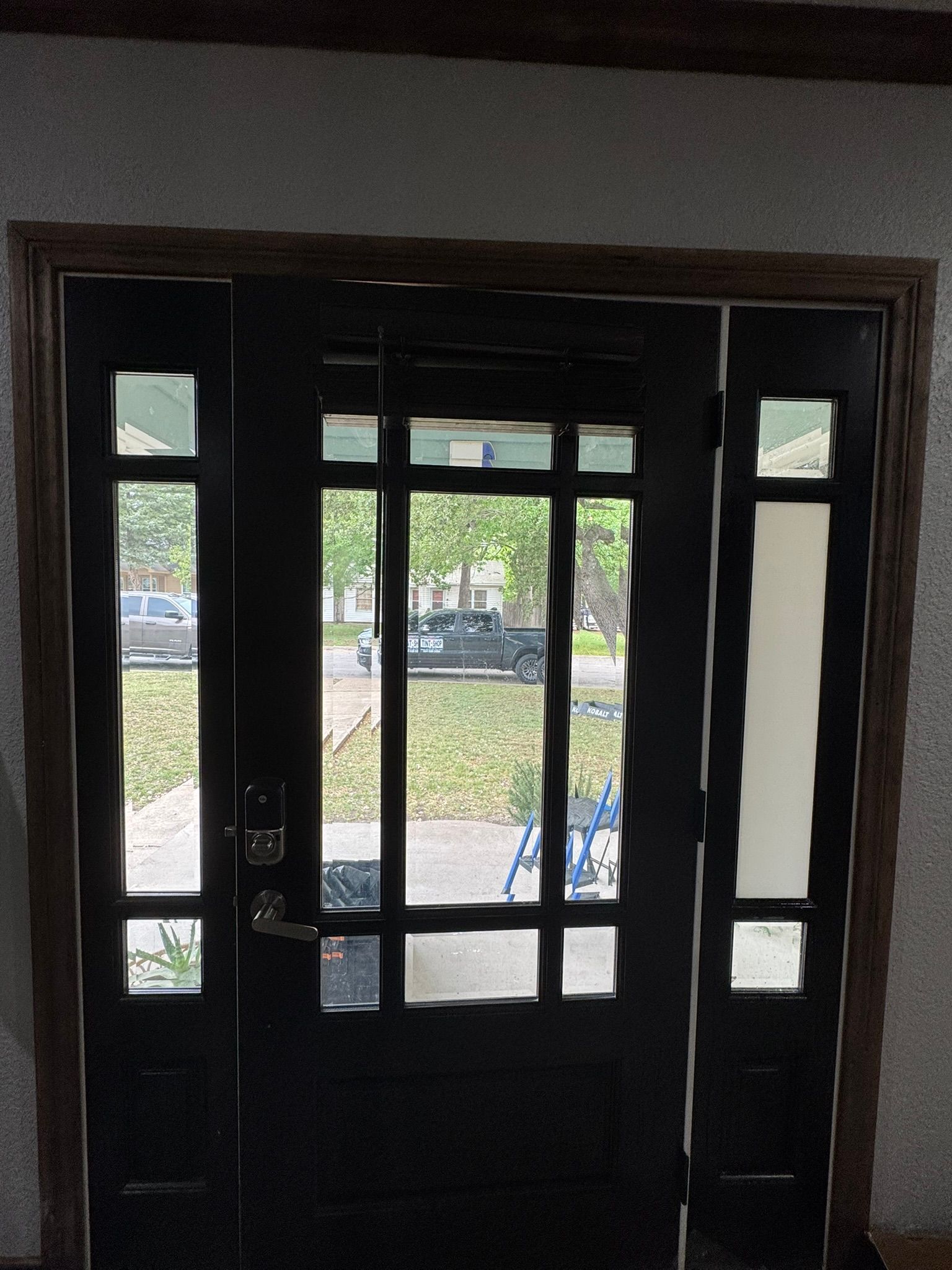 A black door with a view of a car parked in front of it
