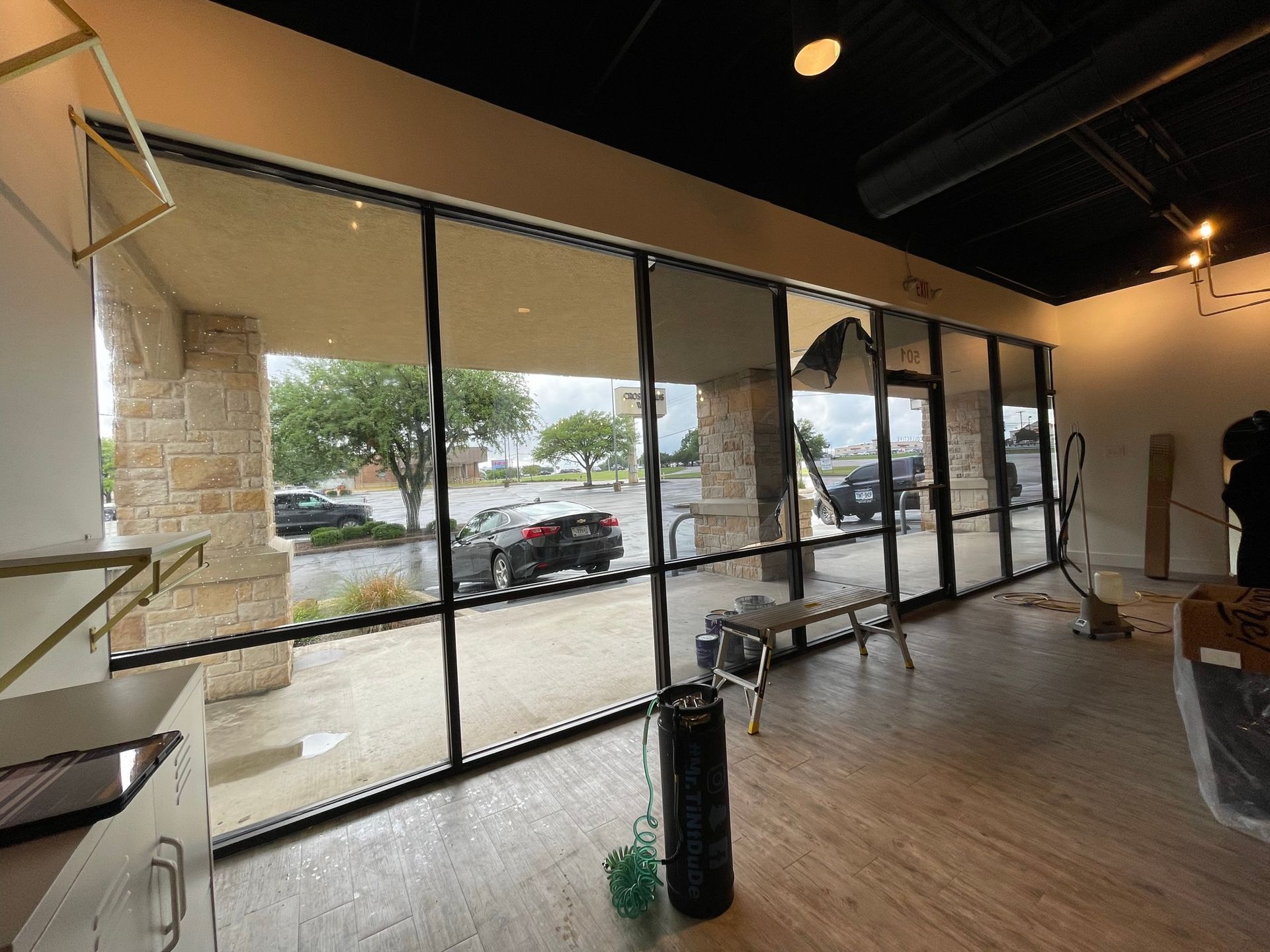 An empty room with a lot of windows and a trash can.