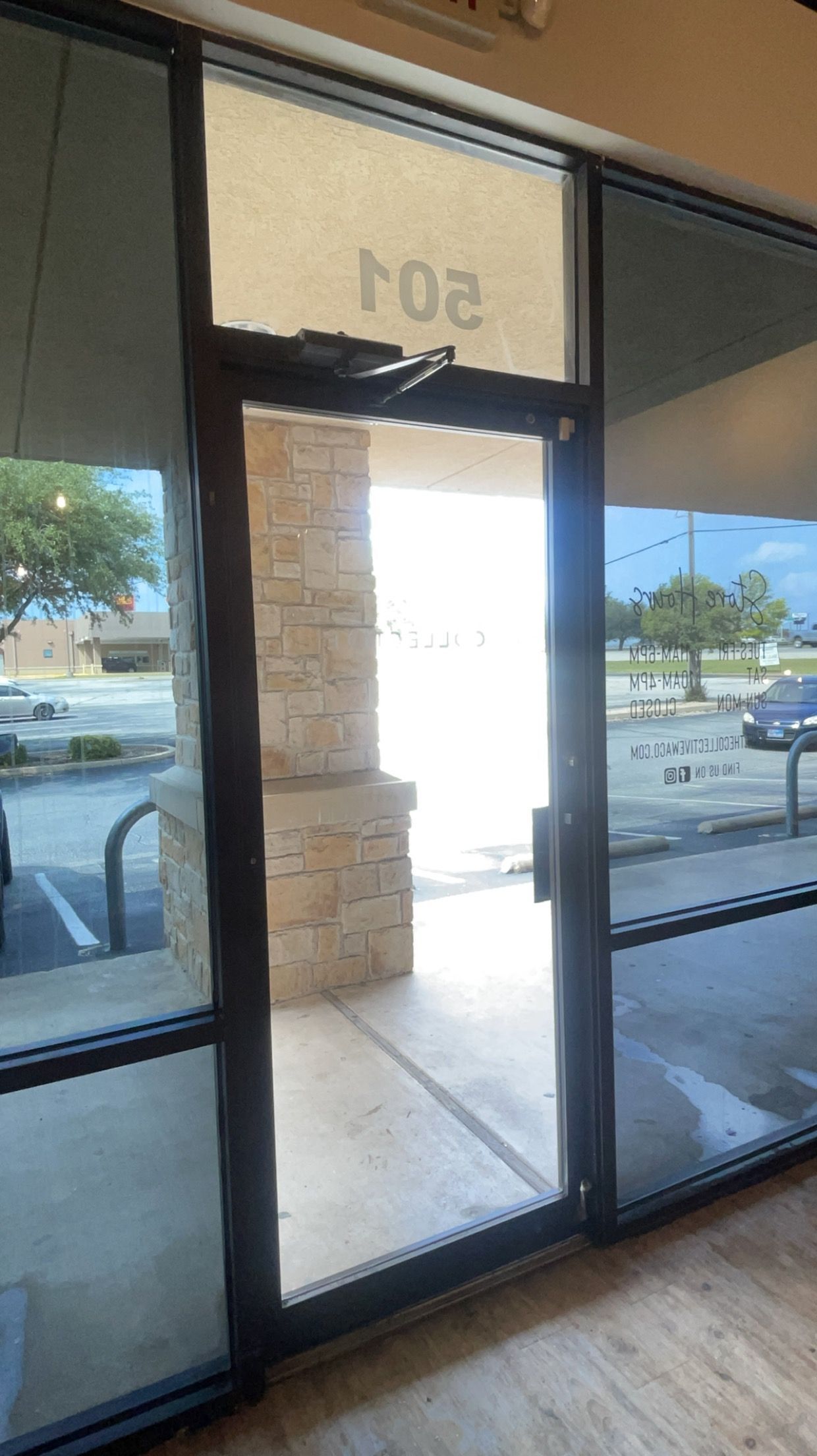 A glass door is open to a parking lot.