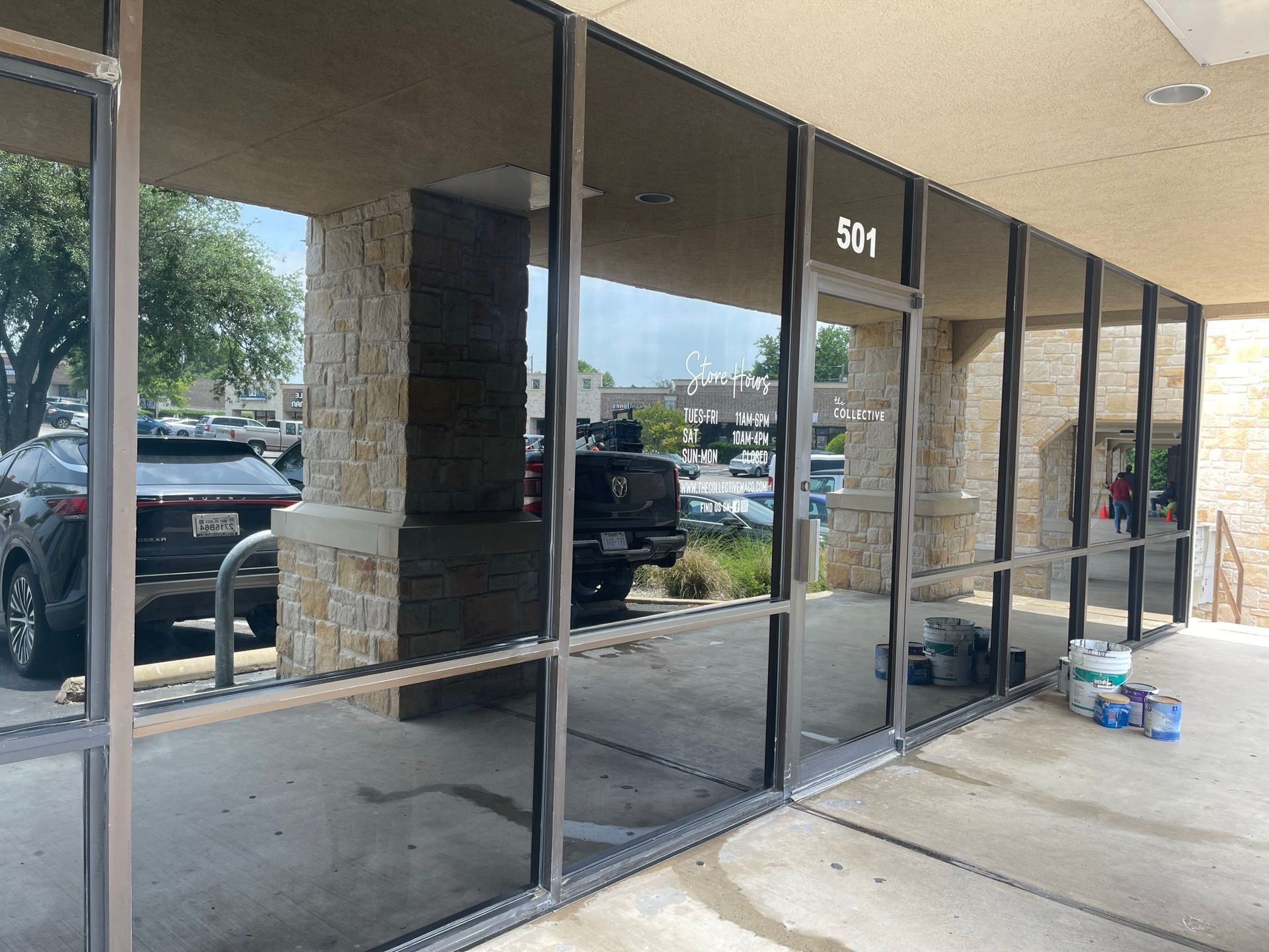 A car is parked in front of a building with a lot of windows.