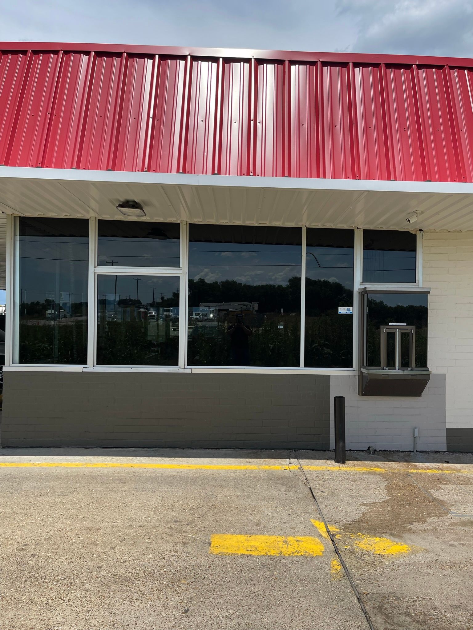 A fast food restaurant with a red roof and a lot of windows.