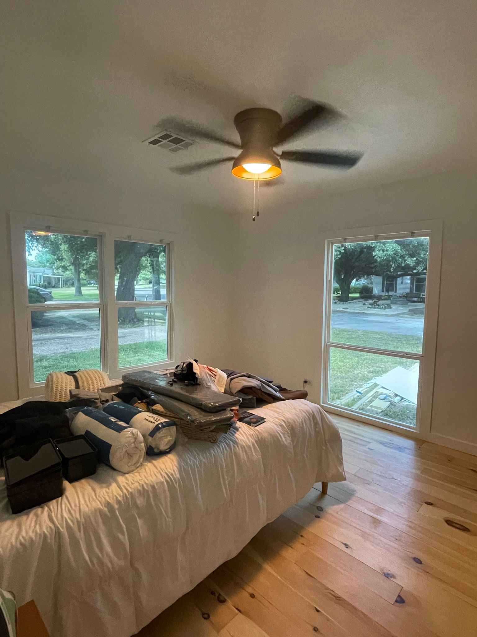 A bedroom with a bed and a ceiling fan.