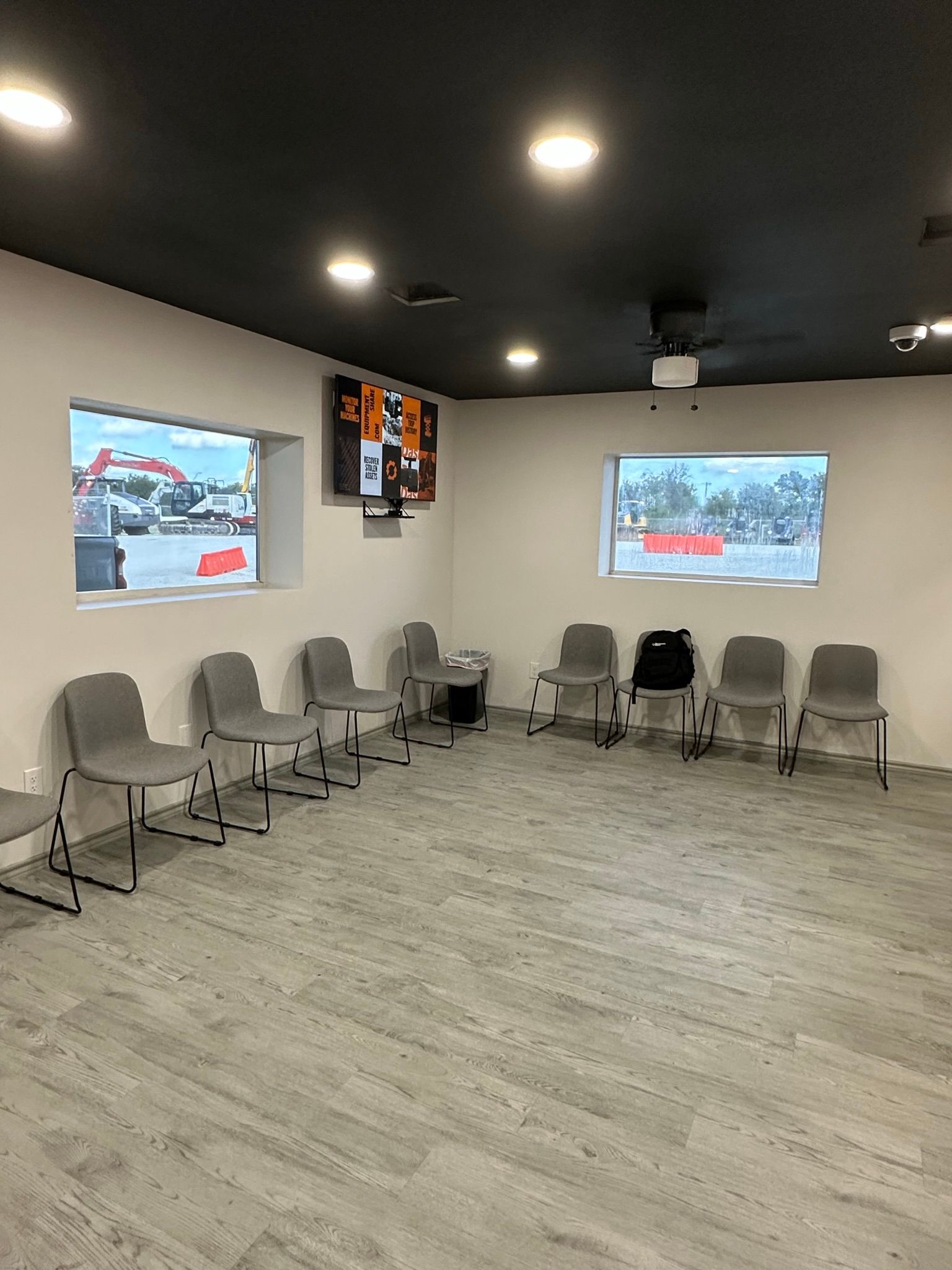 A waiting room with a row of chairs and a window.