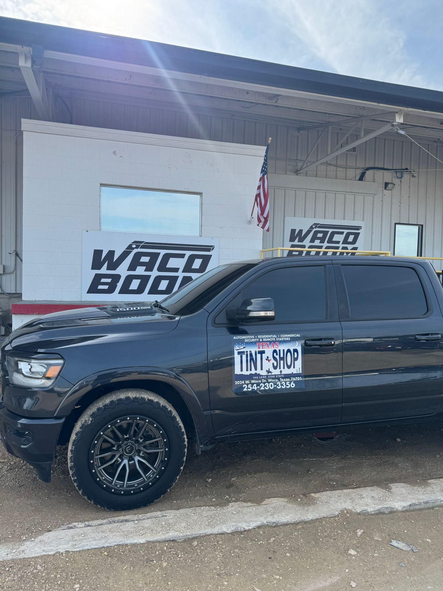 A black truck is parked in front of a building.