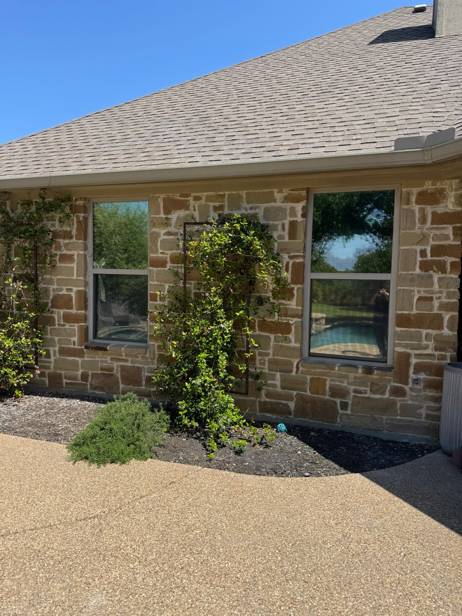 A brick house with a roof and a lot of windows