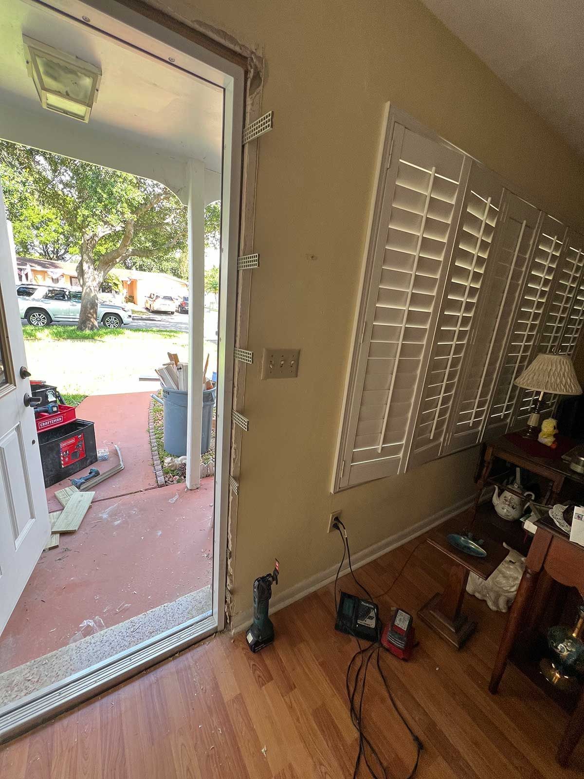 A living room with hardwood floors and shutters on the windows.