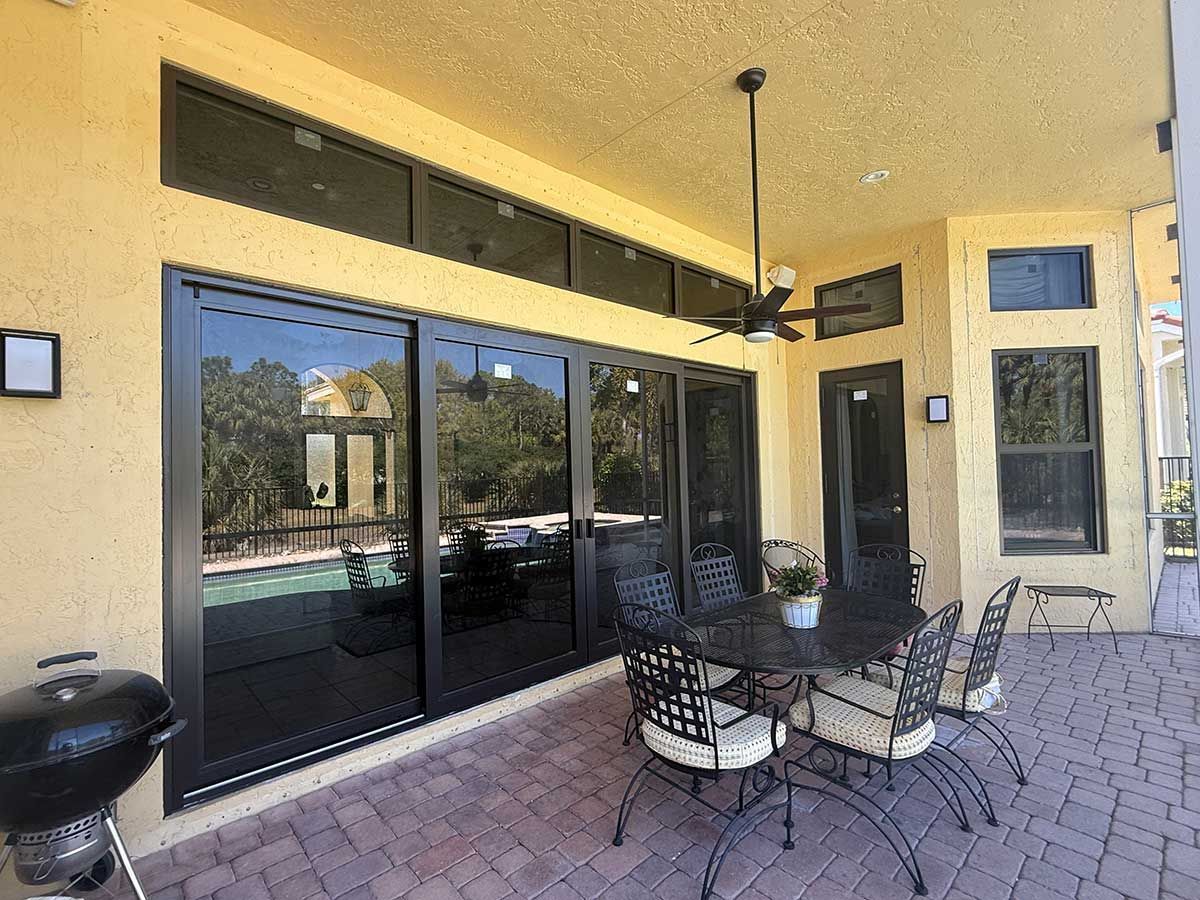 A patio with a table and chairs and a grill.