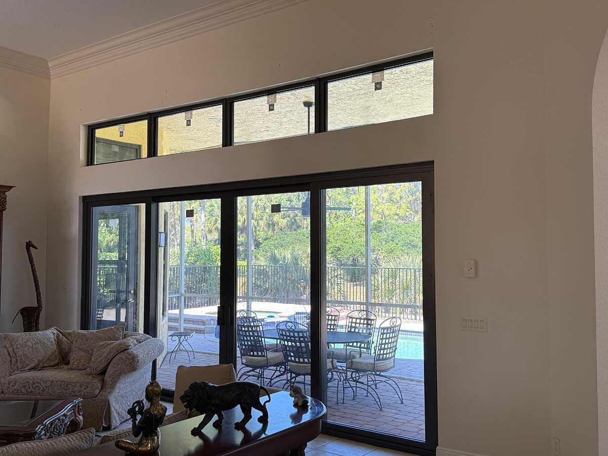 A living room with sliding glass doors leading to a pool.