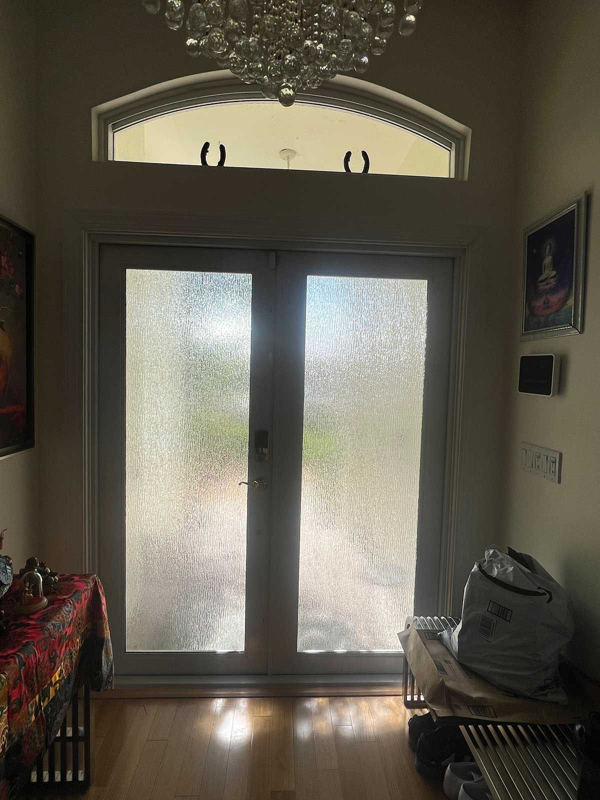 A living room with a chandelier and sliding glass doors.