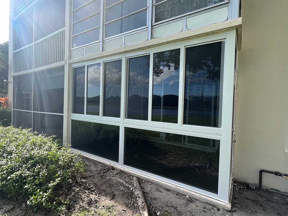 A house with a lot of windows and a screened in porch.