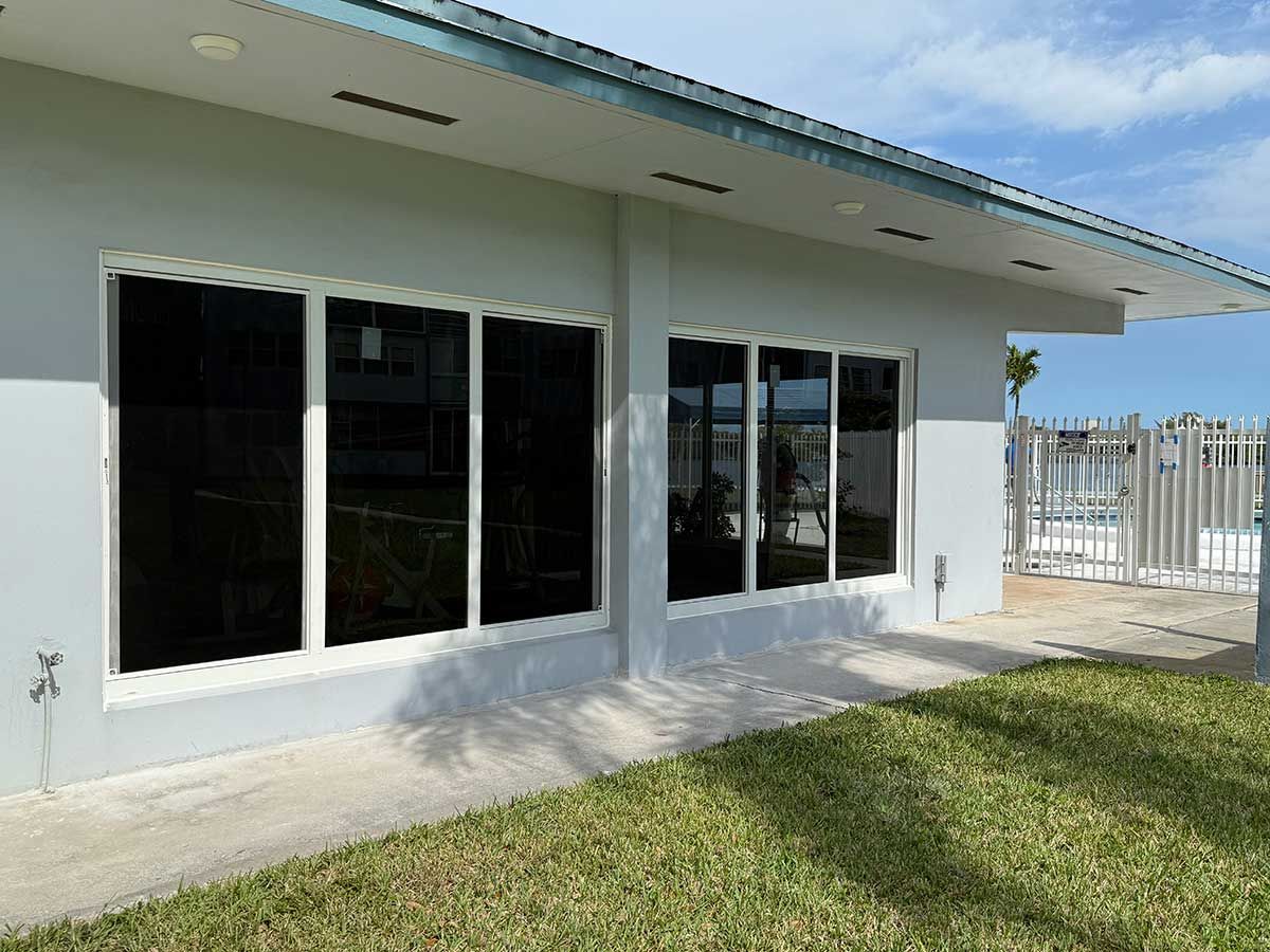 A house with a lot of windows and a lawn in front of it.