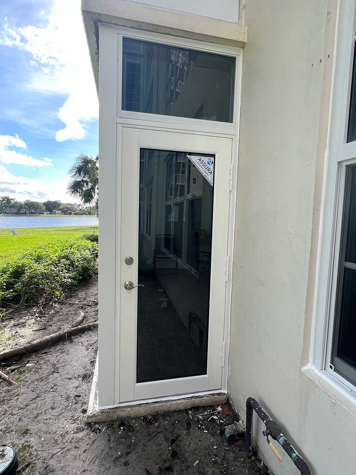 A white door with a glass window on the side of a house.