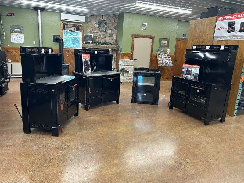 Black wood-burning cook stoves on display in a retail store.