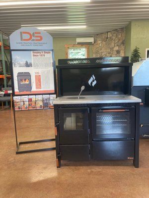 Black wood-burning stove with oven and sink, in a store.
