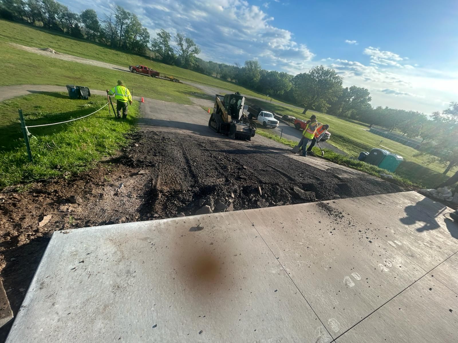 A group of construction workers are working on a road in a park.