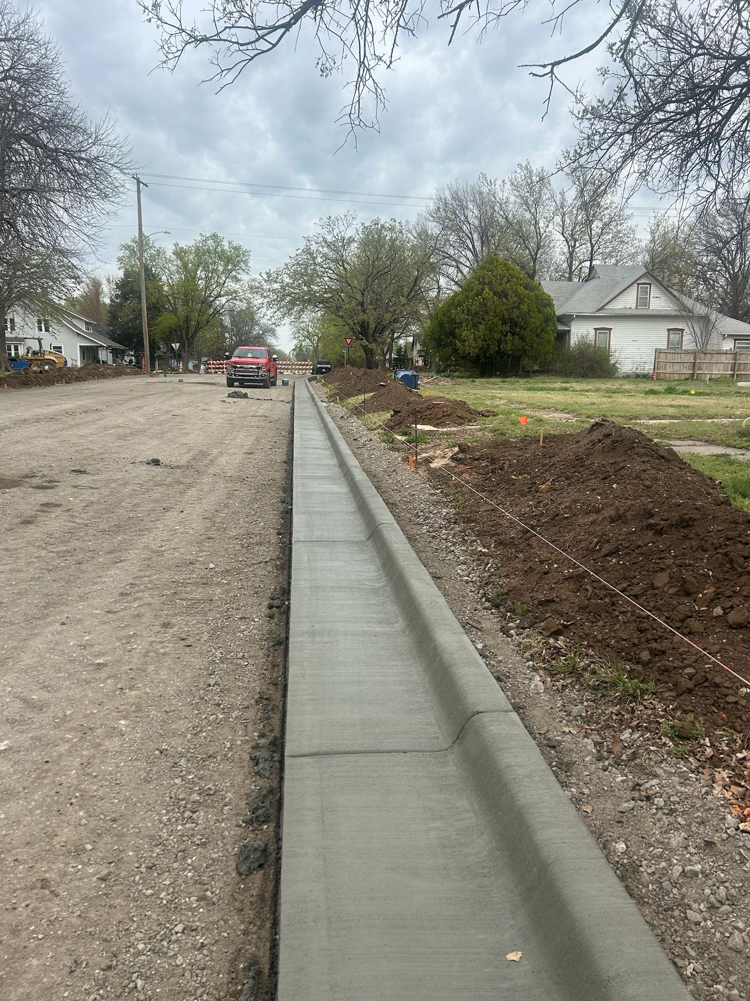 A concrete curb is being built on the side of a road.