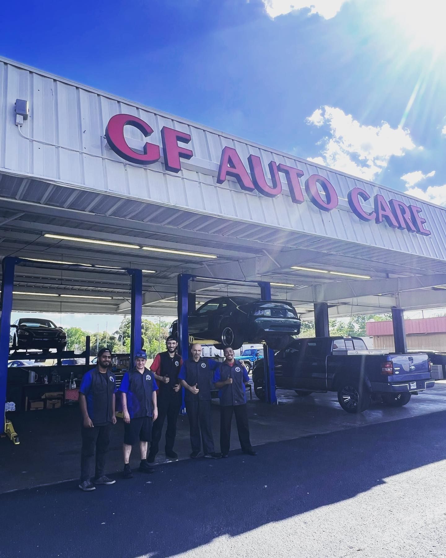 A group of people standing in front of a cf auto care