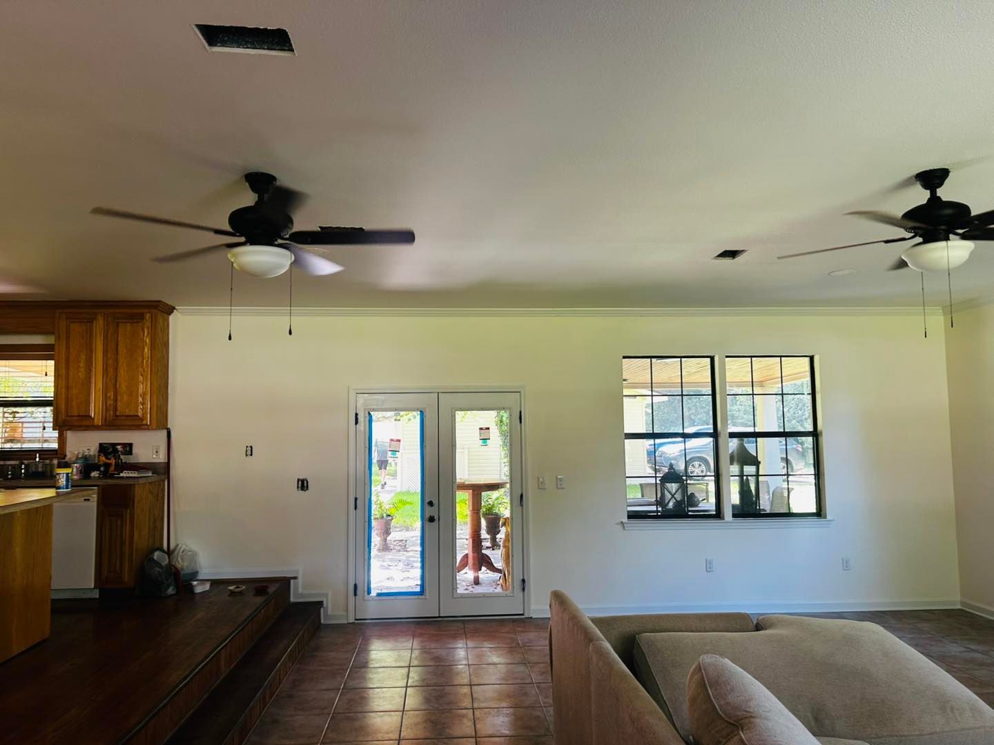 Interior of a room with a raised platform, ceiling fans, a window, and a door leading outside.