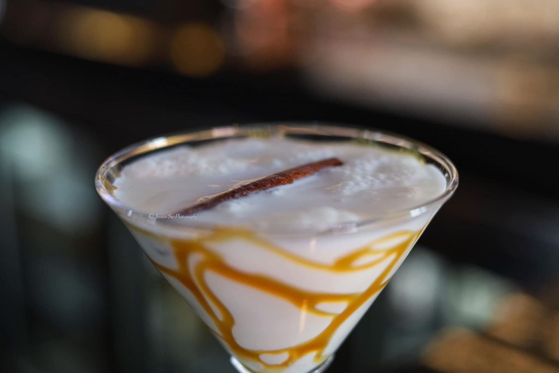 A close up of a martini with a cinnamon stick in it