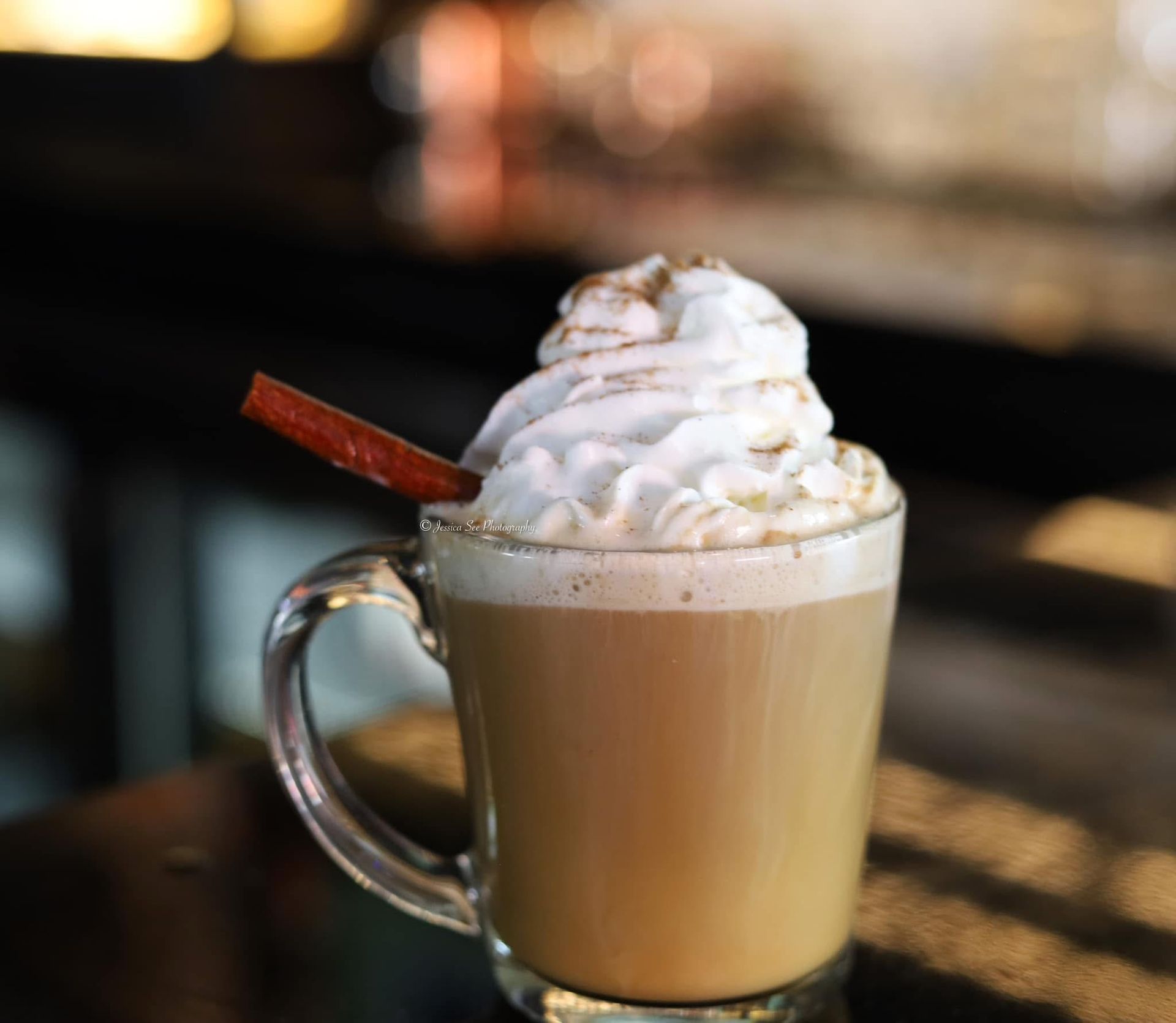 A cup of coffee with whipped cream and a straw