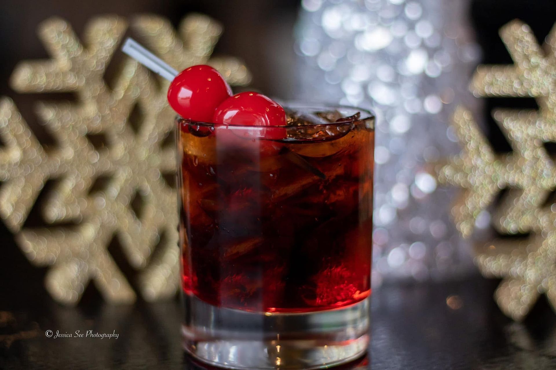 A close up of a drink with a cherry on top on a table