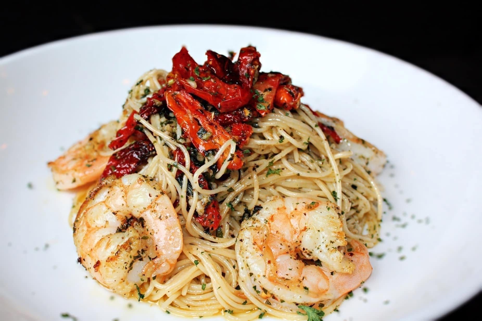 A white plate topped with pasta and shrimp