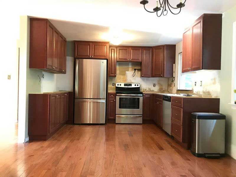 Kitchen with dark wood cabinets, stainless steel appliances, and hardwood floors.