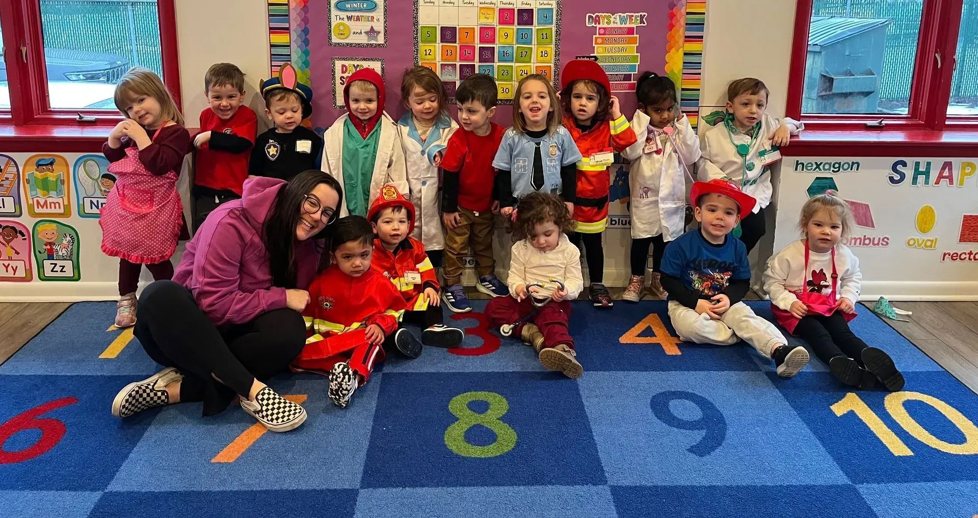 Group of children and teacher posing in front of a