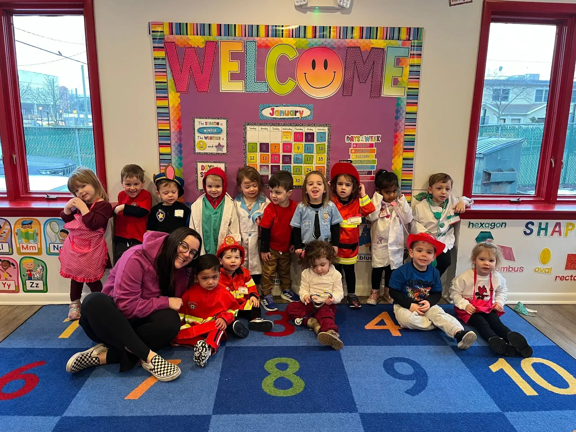 Children and teacher posing in a classroom with a