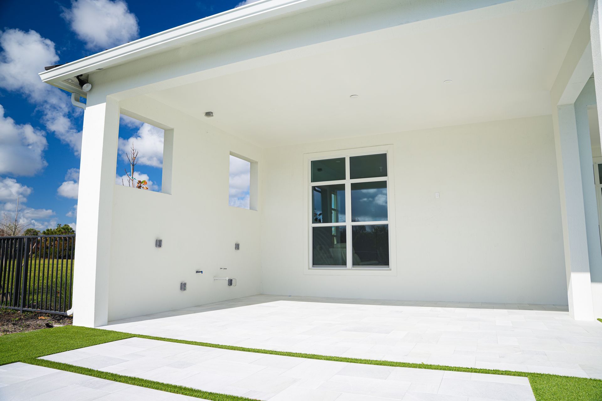 Modern white house patio with covered porch, large window, and sliding glass door